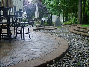 Arbel paver patio with dry river bed and steps leading to backyard